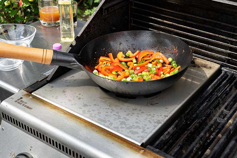 Den Wok nun wieder mit einem EL Erdnussöl benetzen und 
                    anschließend die Paprikastreifen mit den Frühlingszwiebeln anbraten.