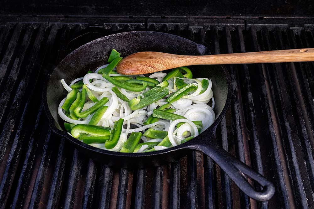 Sobald die Zwiebelringe angedünstet sind, geben wir die Paprikastreifen hinzu und lassen diese ebenfalls mit andünsten.