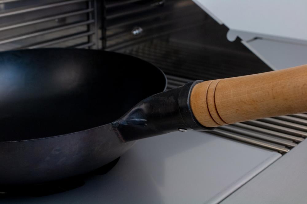 Der Holzgriff ist stabil am Wok befestigt