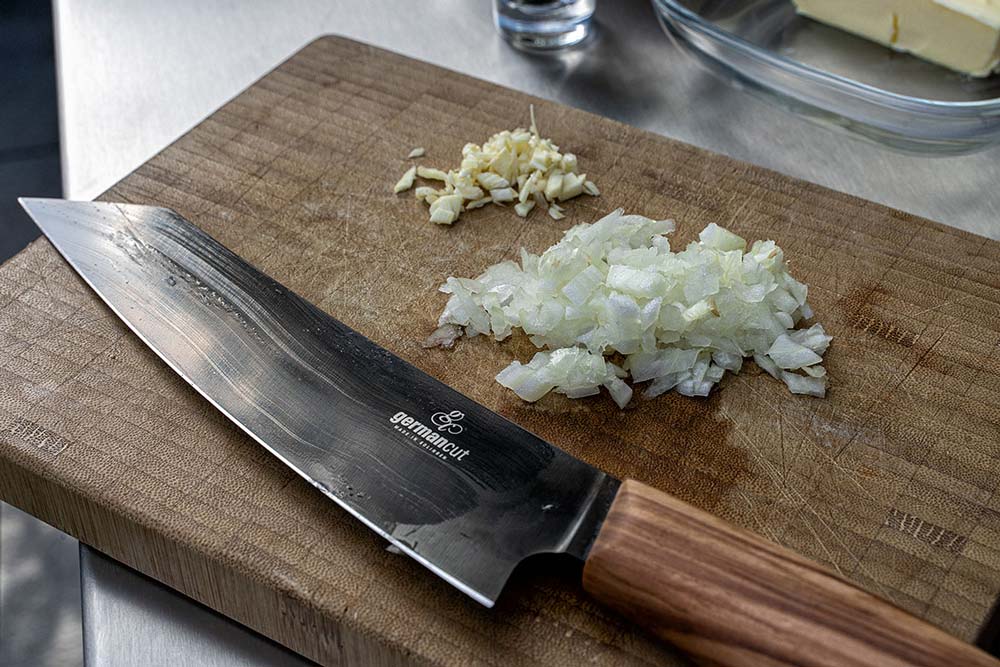 Mit einem scharfen Messer schneiden wir die Schalotte in kleine Würfel und hacken den Knoblauch fein.