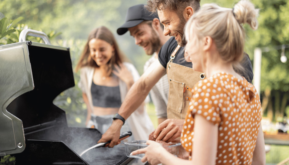 Welcher Grill passt zu mir Titelbild. Eine Familie am Grillen in ihrem Garten, sie lachen und haben eine schöne Zeit.