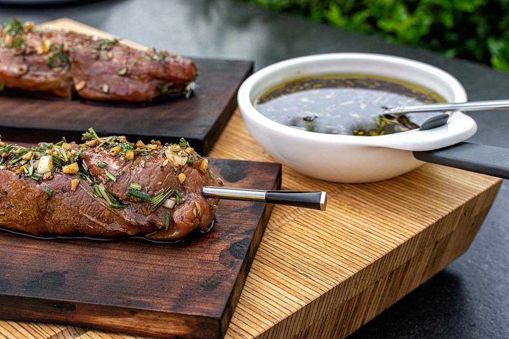 Die Schweinefilets auf die Holzplanke legen und das Thermometer in die dickste Stelle einstechen.