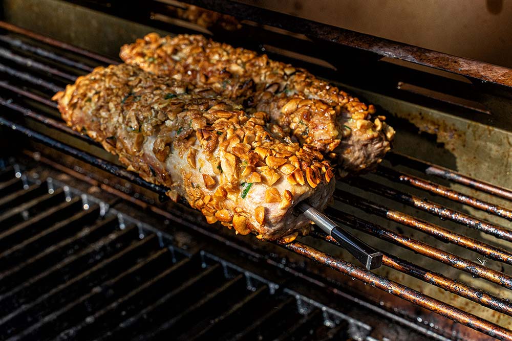 Die Schweinefilets in den indirekten Bereich des Grills legen (z. B. Warmhalterost) und bis zu einer Kerntemperatur von ca. 62 – 65°C nachgaren.