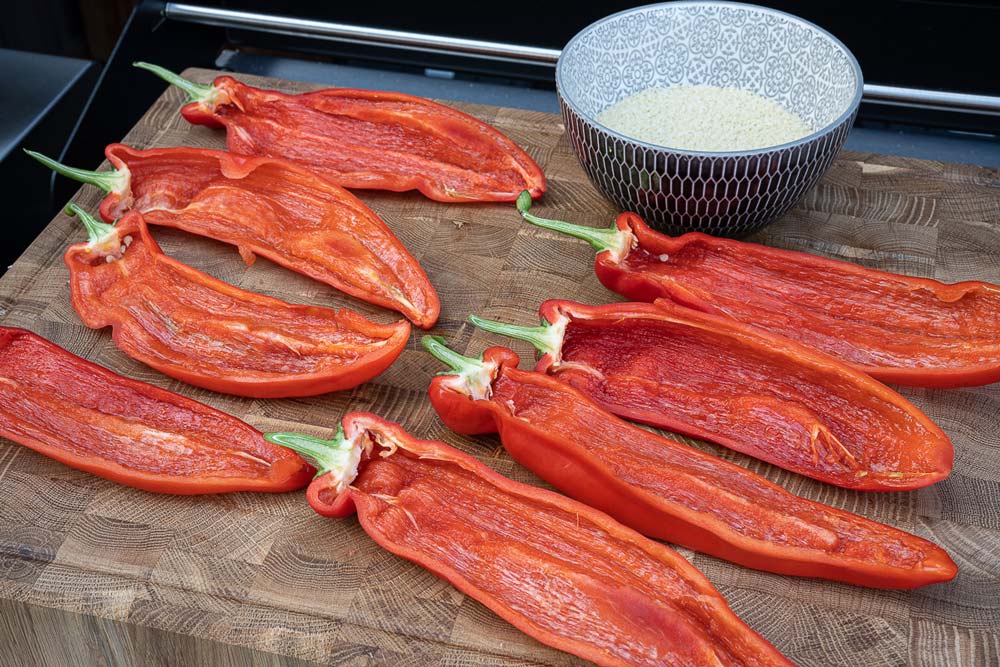 Die Spitzpaprika unter fließendem Wasser waschen, mit einem Küchentuch trocken tupfen, 
                    längs teilen und entkernen. Den Couscous mit heißem Wasser aufgießen.