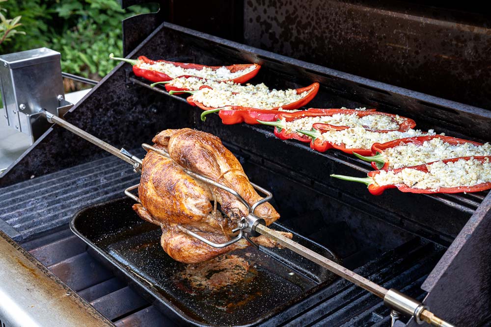 10 – 15 Minuten bevor das Hähnchen fertig gegrillt ist, 
                    die gefüllten Spitzpaprika-Hälften auf den Warmhalterost des Grills platzieren. 
                    Die gefüllte Spitzpaprika ist fertig gegart, sobald die äußere Schale weich geworden ist.