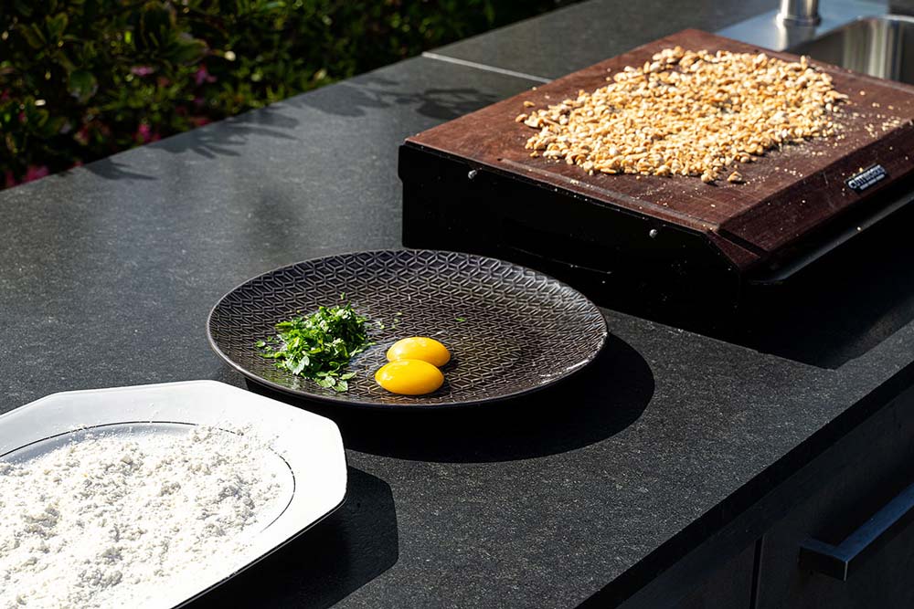 Die Panierstraße mit einem Mehl-Teller, einem Eier-Teller und einem Erdnuss-Teller/Brett aufbauen.