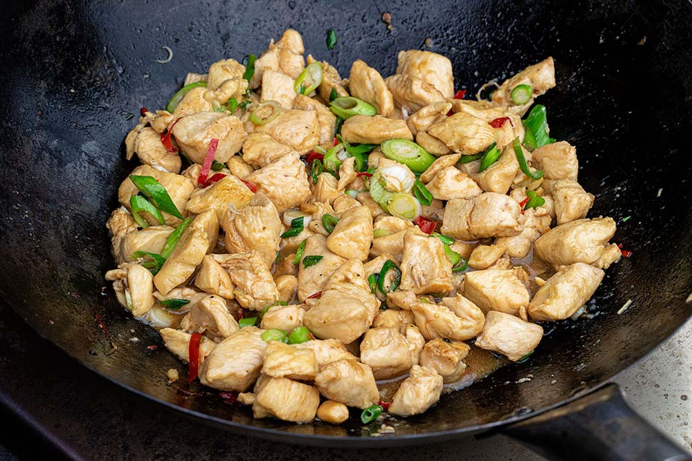 Nun die Sauce hinzugeben, kurz aufkochen lassen und zu guter Letzt die gerösteten Erdnüsse und die Frühlingszwiebeln unterheben.