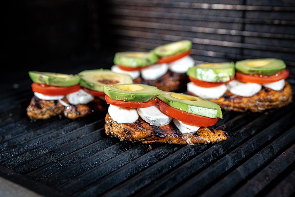 Belege das Fleisch mit Mozzarella, Tomaten und Avocado. Gare bis 82°C Kerntemperatur. 
                    Vor dem Servieren mit Balsamico-Creme und Basilikum verfeinern.