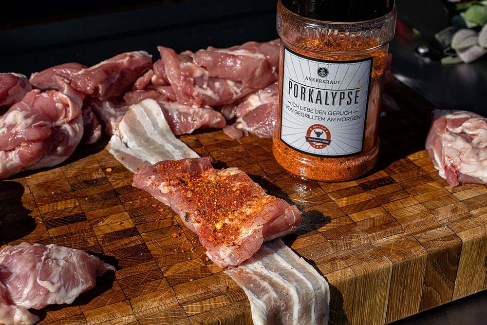 Ein einzelnes Stück legen wir nun auf einen Streifen Bacon und geben etwas von unserem BBQ-Rub auf das Stück Kachelfleisch.