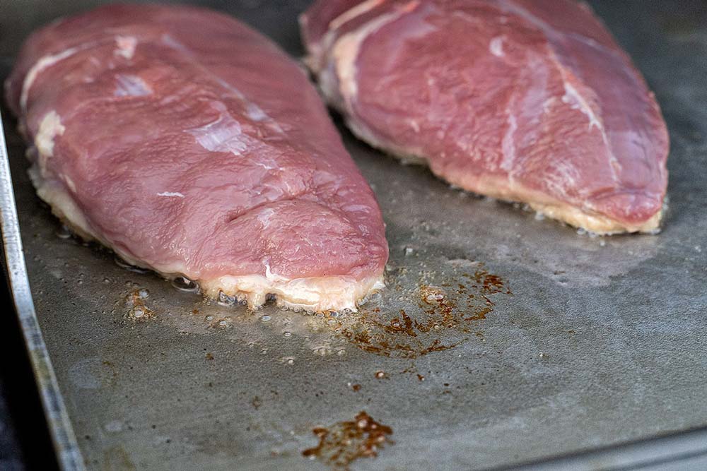 Sobald das Fett austritt, Hitze erhöhen, sodass die Haut in ihrem eigenen Fett brät.