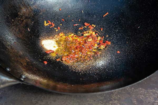 Die klein geschnittene Chili und den Ingwer zusammen mit dem gemahlenen Fenchel und den granulierten Zwiebeln anbraten.