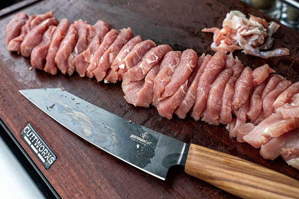 Das Schweinefilet mit einem scharfen Messer parieren und 
                    in relativ dünne, mundgerechte Stückchen schneiden.