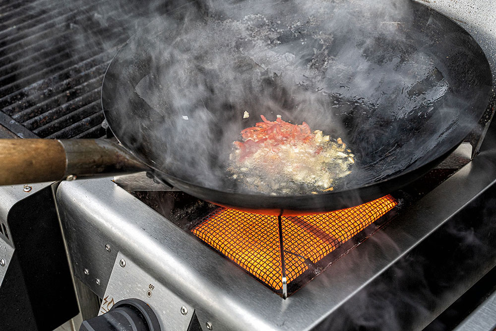 Zwiebeln in Streifen schneiden, Cocktailtomaten 
                    halbieren, Chili und Knoblauch hacken. 
                    Wok mit Sesamöl benetzen, Chili und Knoblauch andünsten, 
                    dann Zwiebeln hinzufügen und weiterdünsten.