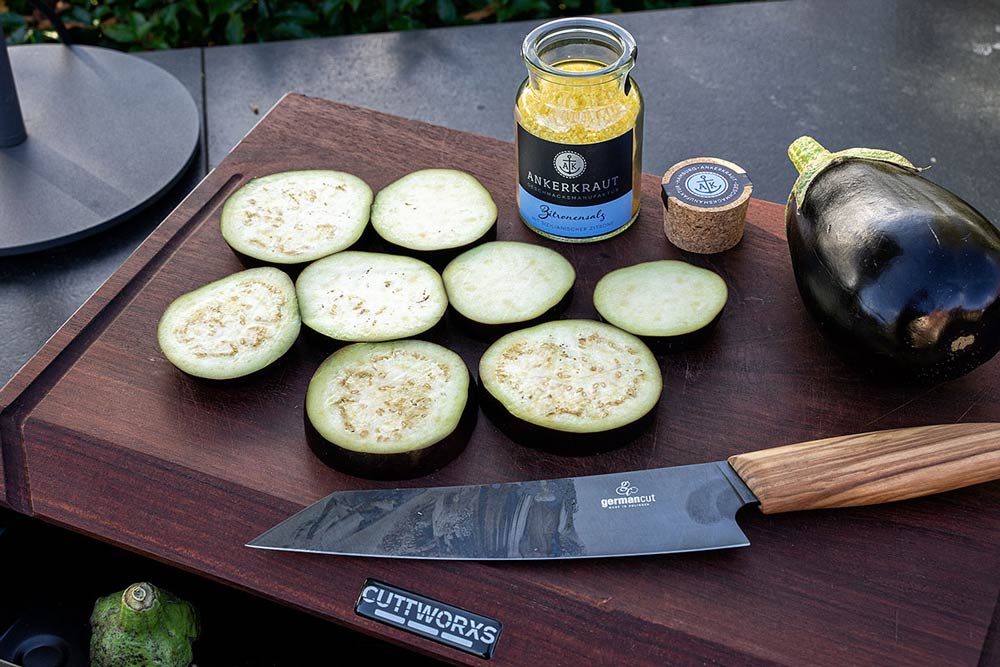 Auberginen waschen, in 1cm dicke Scheiben schneiden und mit Zitronensalz bestreuen.