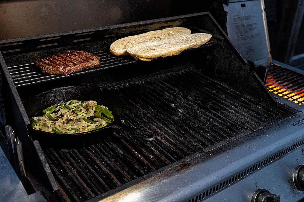 Ist das Steak angegrillt, sollte es bei einer Garraumtemperatur zum Nachziehen 
                    in den indirekten Bereich des Grills gelegt werden. 
                    Hier kann es auf eine Kerntemperatur von ca. 50 Grad nachziehen. 
                    Ebenfalls kann man das Baguette mit auf den Grill legen. 
                    Währenddessen kann man die Edelstahlschale auf dem Grill 
                    mit erwärmen und das Gemüse warmhalten.