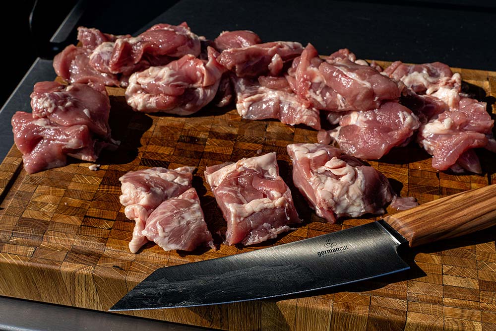 Wir schneiden die einzelnen Stücke des Kachelfleisches in 3 gleich große Stücke.