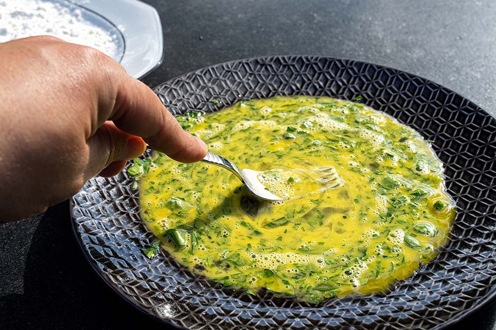 Vor dem Panieren verquirlen wir die Eier mit der Petersilie.