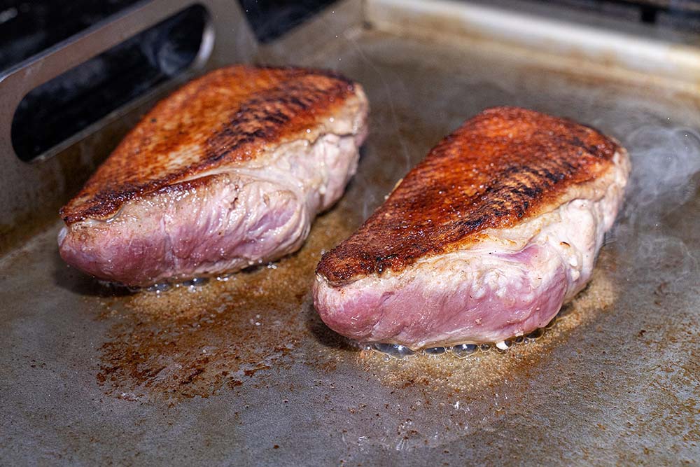 Entenbrüste wenden und auf der Fleischseite scharf anbraten.