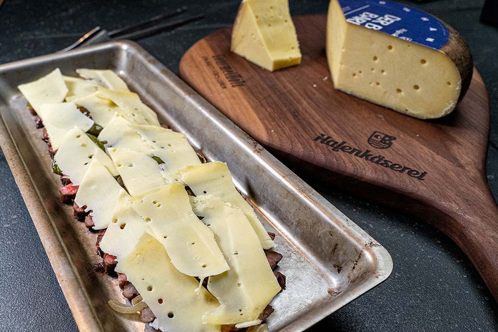 Anschließend verteilen wir die Käsescheiben darauf.