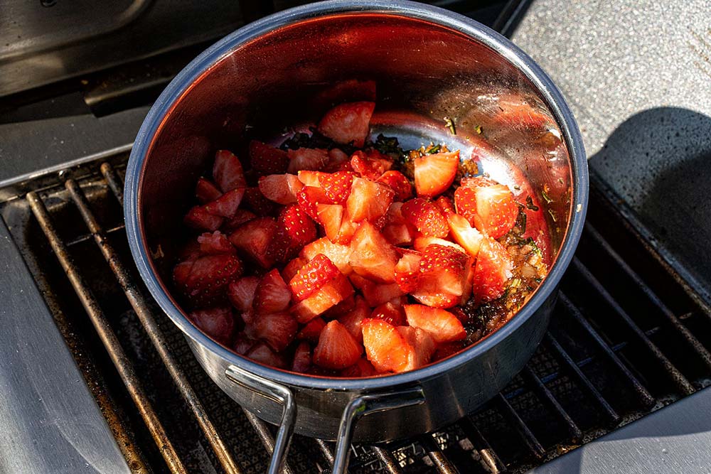 Die gewürfelten Erdbeeren hinzugeben und mit Chiliflocken und feinem Meersalz leicht würzen.
