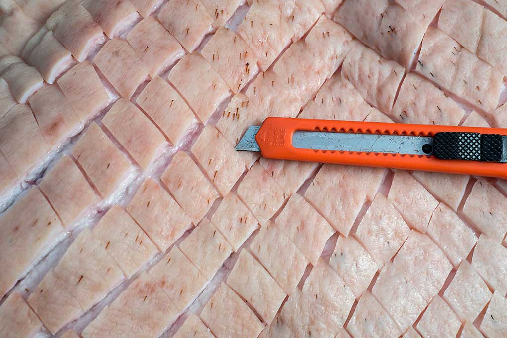 Rautenmuster in Schweinebauch schneiden