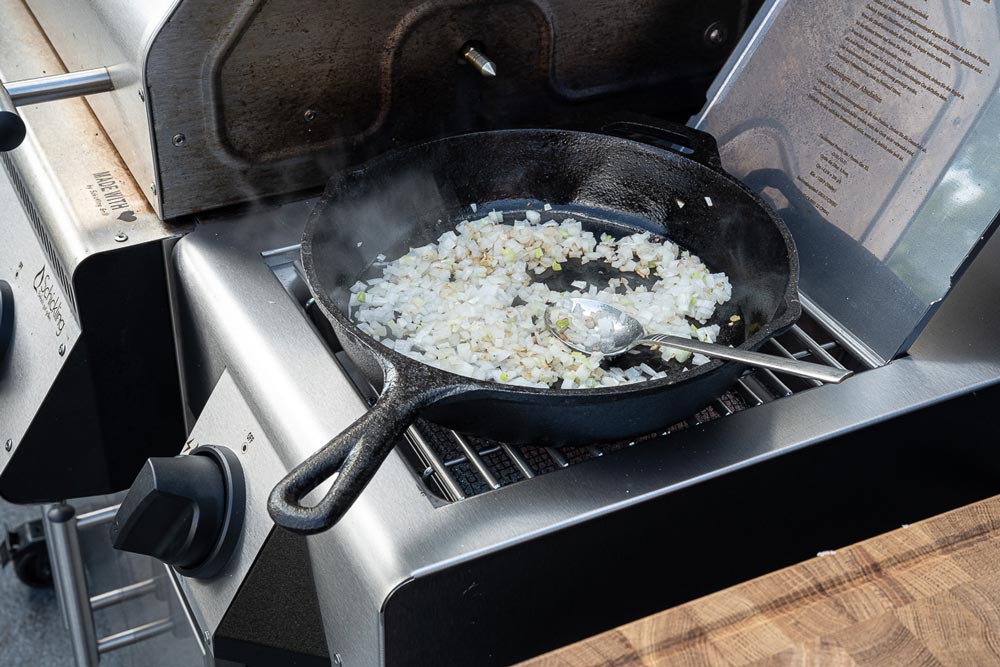 Währenddessen die Zwiebel in Würfel schneiden und anschließend 
                    in einer Pfanne auf dem Seitenbrenner des Grills anschwitzen.
