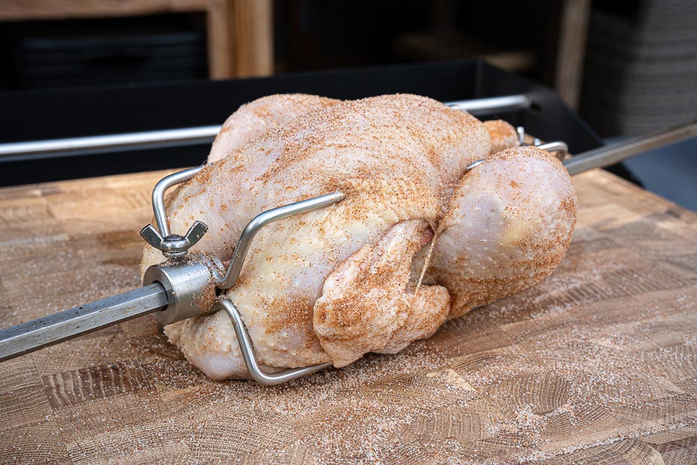 Das Hähnchen unter fließendem Wasser waschen, 
                    mit einem Küchentuch trocken tupfen und anschließend auf den Drehspieß stecken. 
                    Erst jetzt gleichmäßig mit Hähnchengewürz bestreuen.