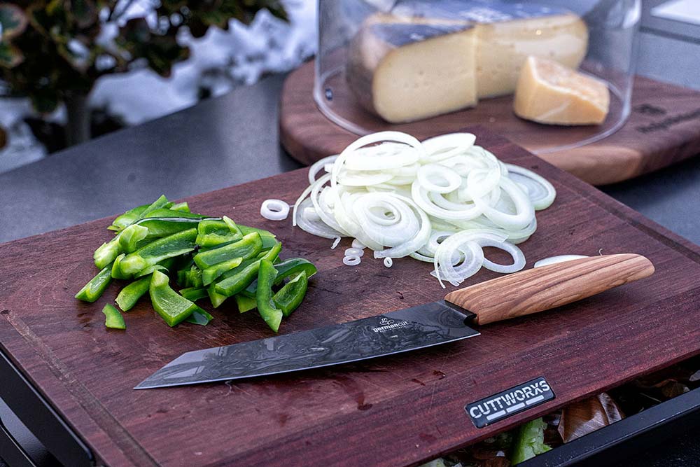 Zuerst schälen wir die Zwiebeln und schneiden diese in dünne Ringe. 
                    Anschließend entkernen wir die Paprika und schneiden diese in feine Streifen.