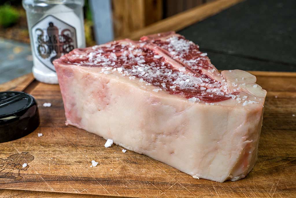 US T-Bone Steak mit Salz bestreuen