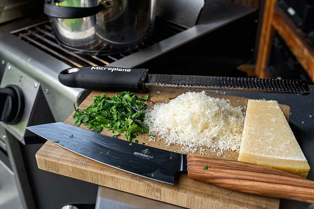 Gebe nach und nach Gemüsebrühe hinzu, bis der Reis keine Flüssigkeit mehr aufnimmt. Gare das Risotto bei schwacher Hitze 20 Minuten. Hacke währenddessen Petersilie und reibe Parmesan.