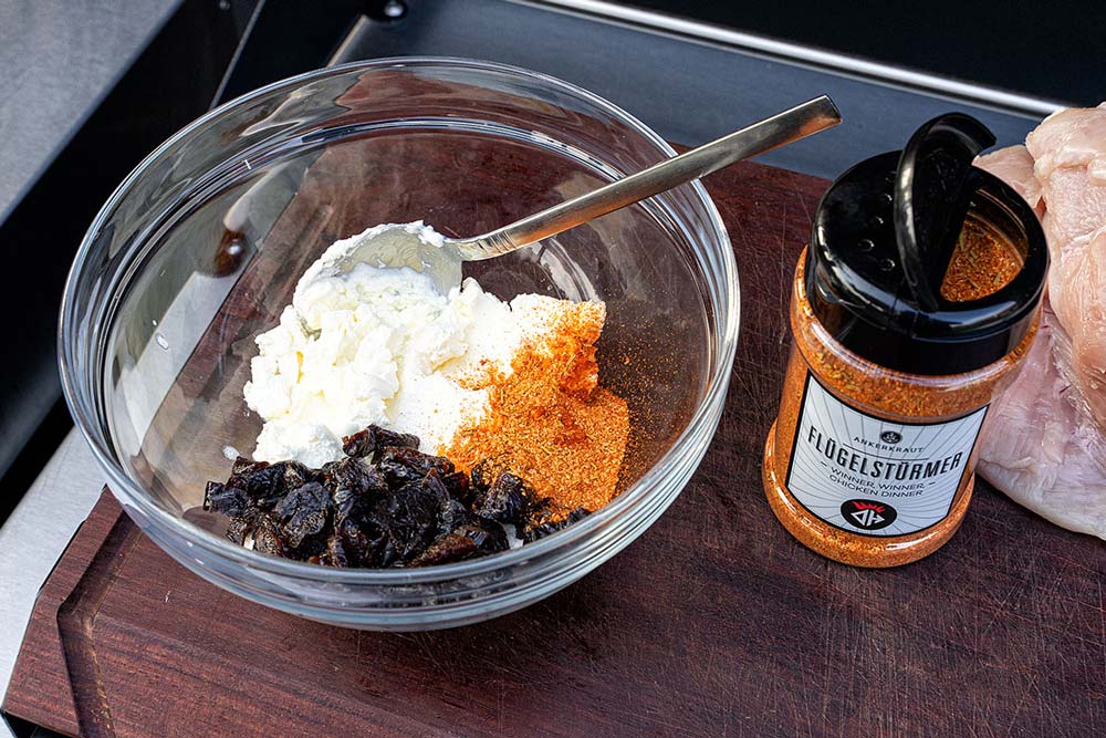 Wir mischen nun die kleinen Pflaumen mit dem Frischkäse und 2 EL unseres Geflügelgewürz.