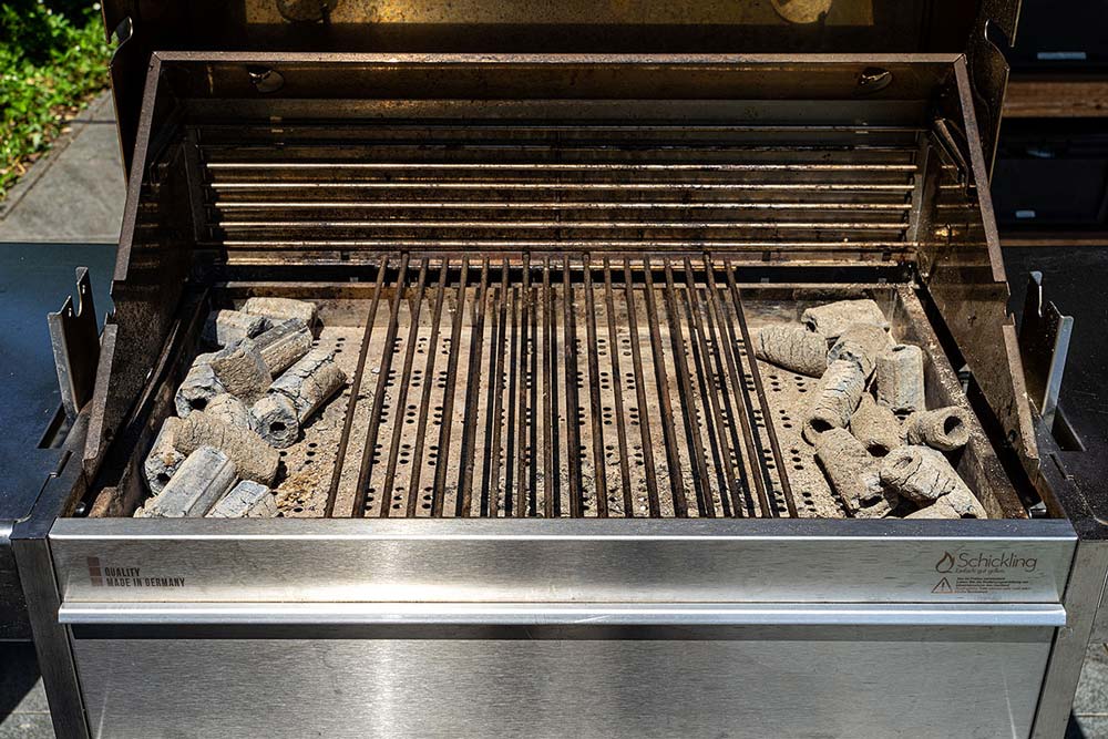 Wir verteilen die Briketts auf der rechten und linken Seite. So entsteht in der Mitte der Grillfläche eine große indirekte Zone.